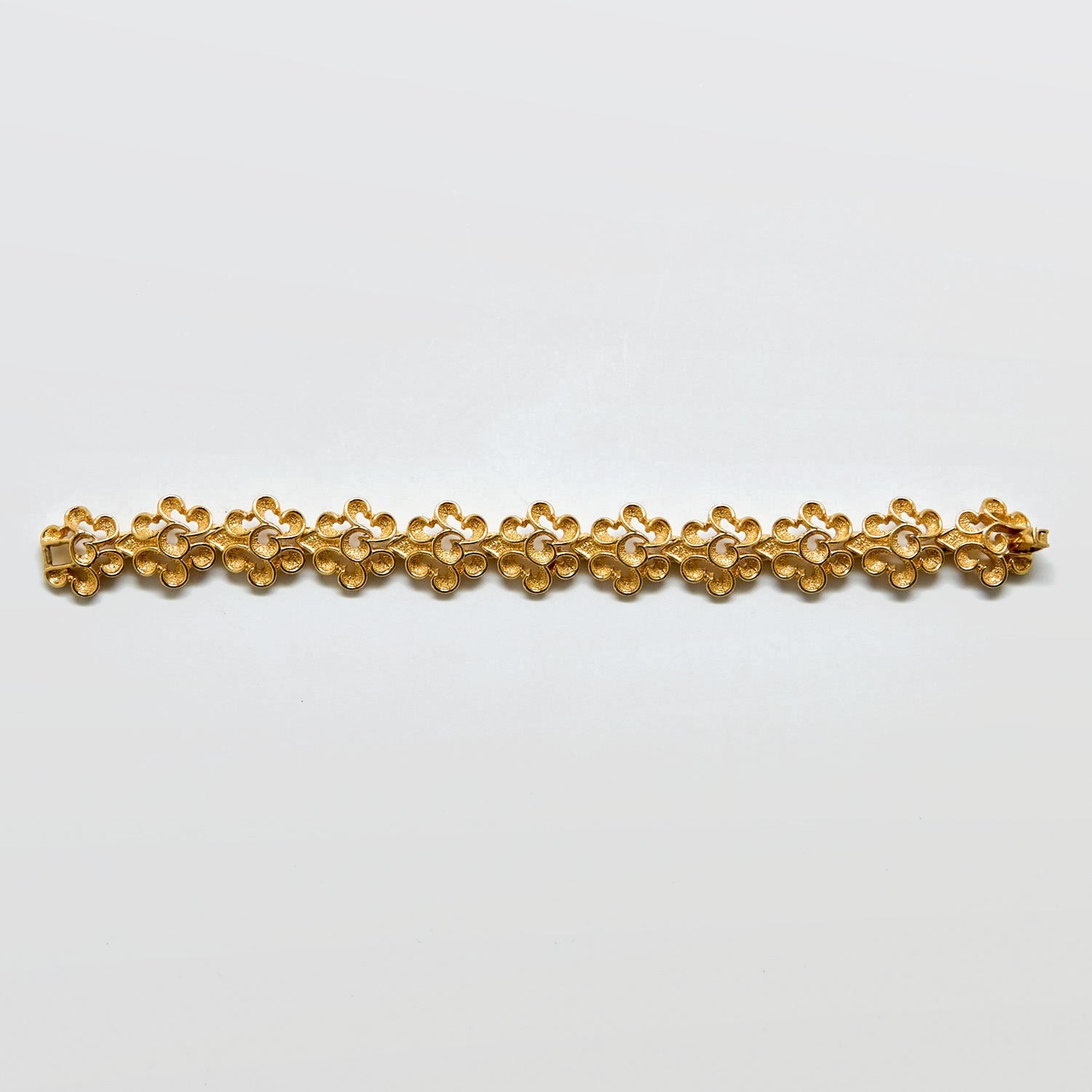 Gold bracelet on a light gray background