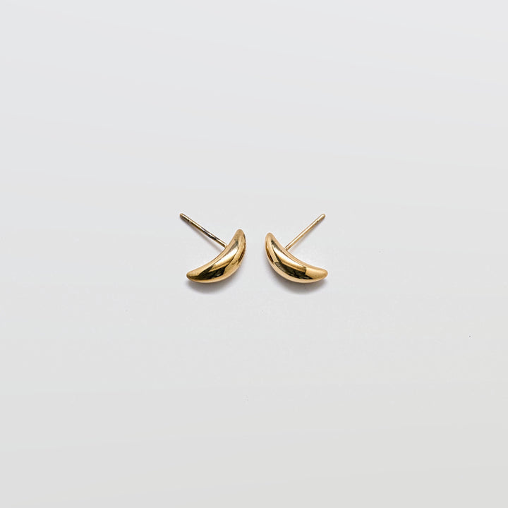 Pair of small curved gold stud earrings with a smooth polished finish and post backs against a white background