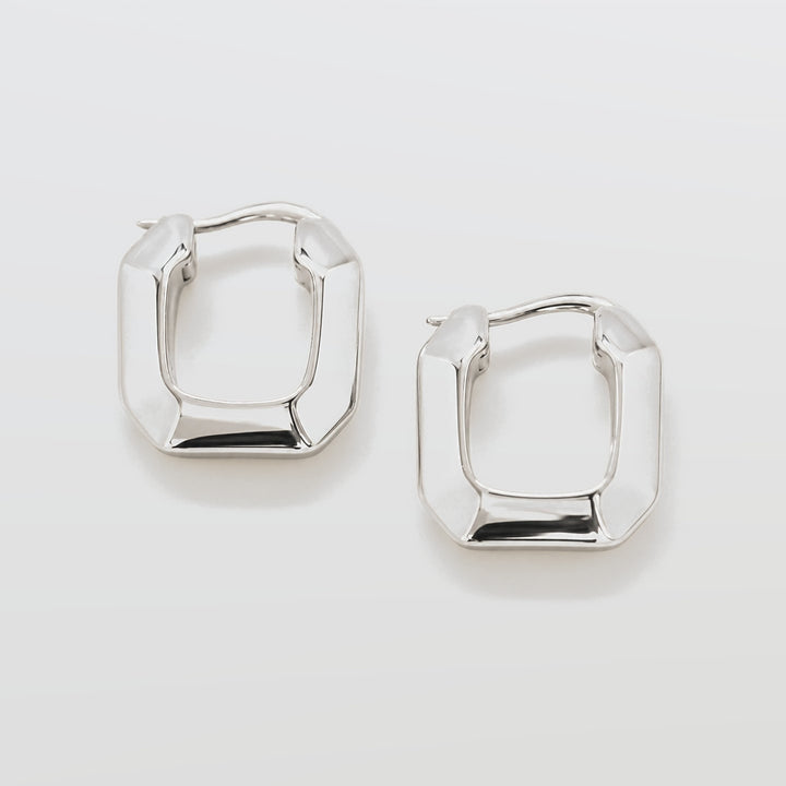 Pair of silver hoop earrings on a light gray background