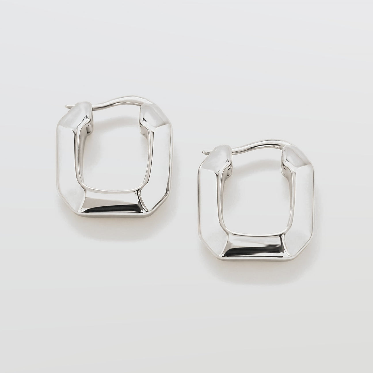 Pair of silver hoop earrings on a light gray background