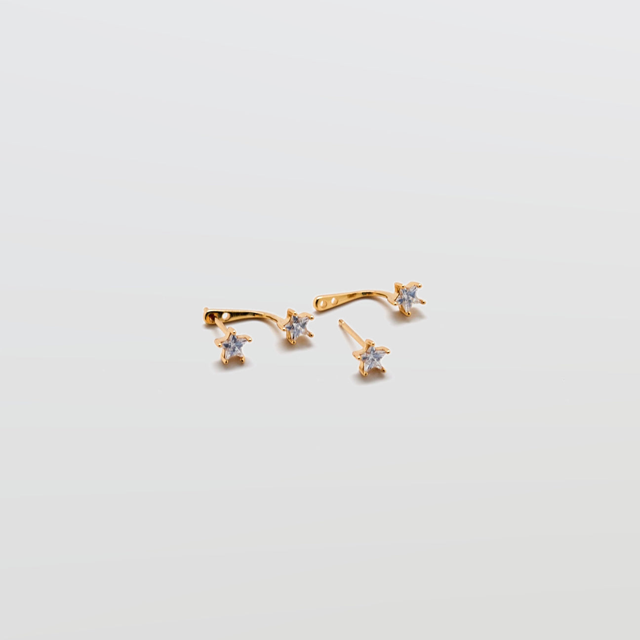 Gold Double CZ Stud Ear Jacket Earrings with cubic zirconia studs and curved ear jacket backing on white background.