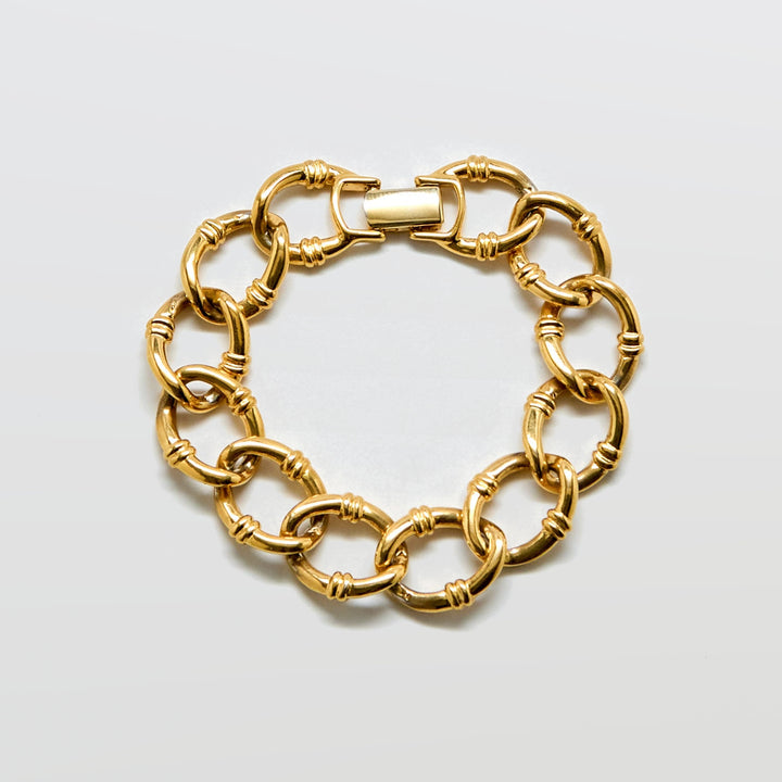 Gold chain bracelet on a light gray background