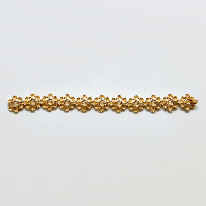 Gold bracelet on a light gray background