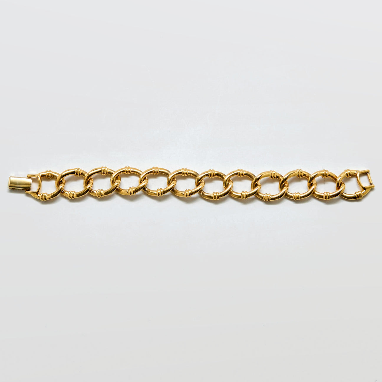 Gold chain bracelet on a light gray background